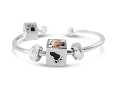 a silver bracelet with a baby's foot and paw print on it